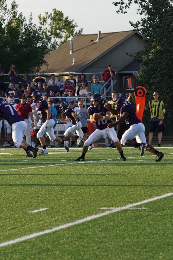 Senior quarterback Dalton White hands the ball off to sophomore Lajames White. 