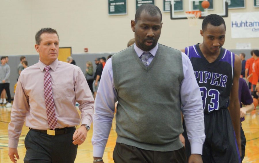 Head coach Toure Grimes and assistant coach Gary Beashore walk off the court with Sophomore Tomar Bates. Bates is ranked 5th in the state of Kansas for the class of 2021.