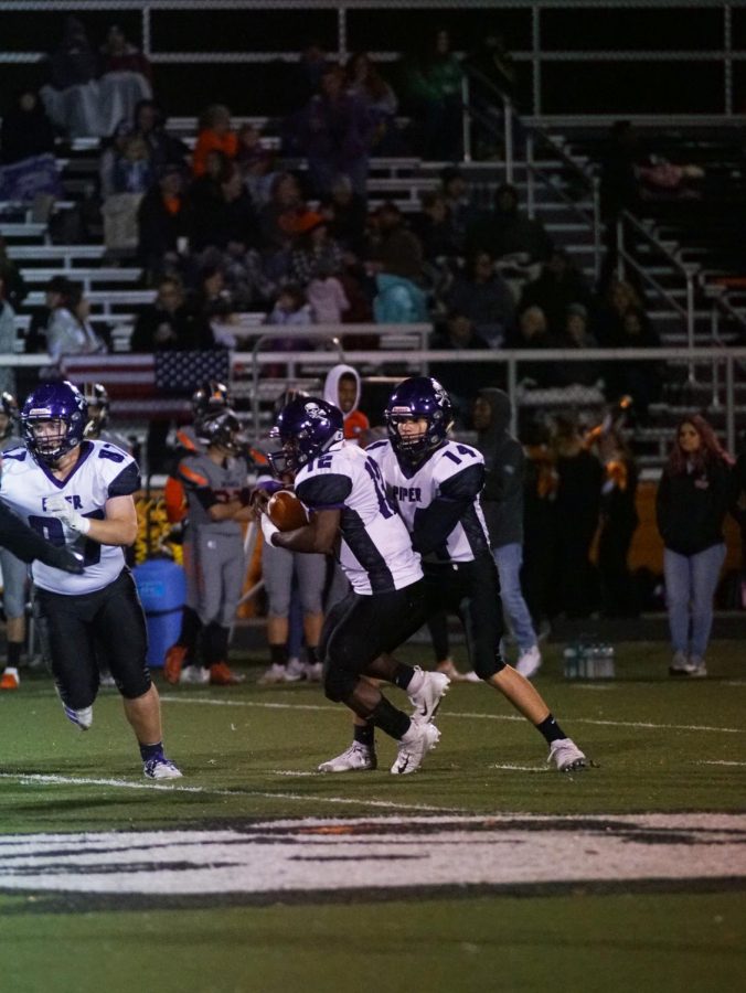 Freshman quarterback Logan Ladish hands the ball off to LaJames White in the fourth quarter. 