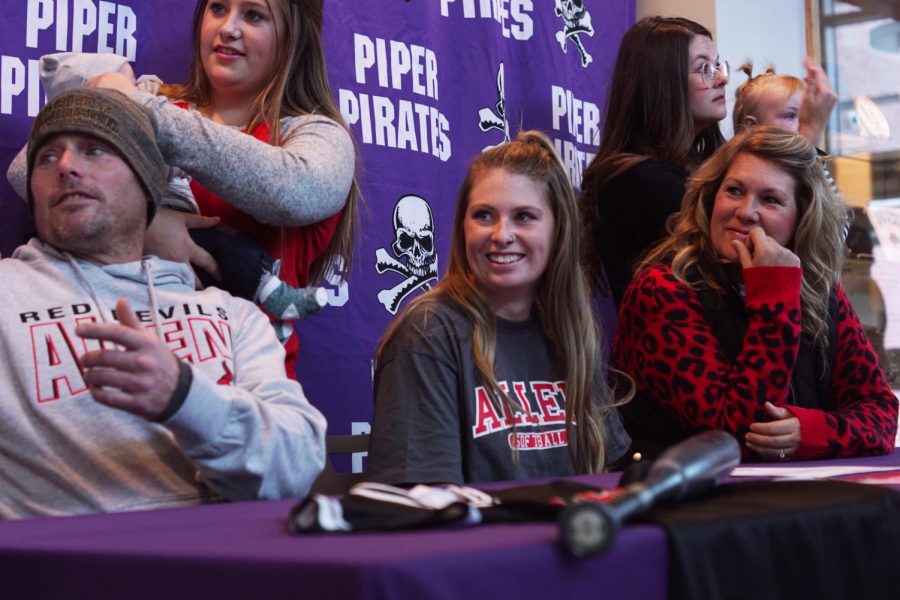 Senior Bella Gravatt shares a laugh with her sisters as her family joins her at her signing. Gravatt will be playing middle infield at Allen County Community College. 