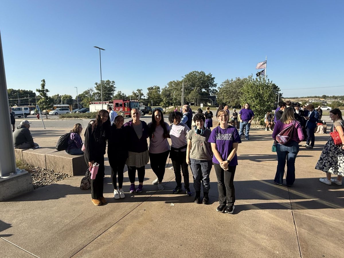 Judges and participants wait outside Piper High School after a pulled fire alarm interrupted round five of the debate tournament.